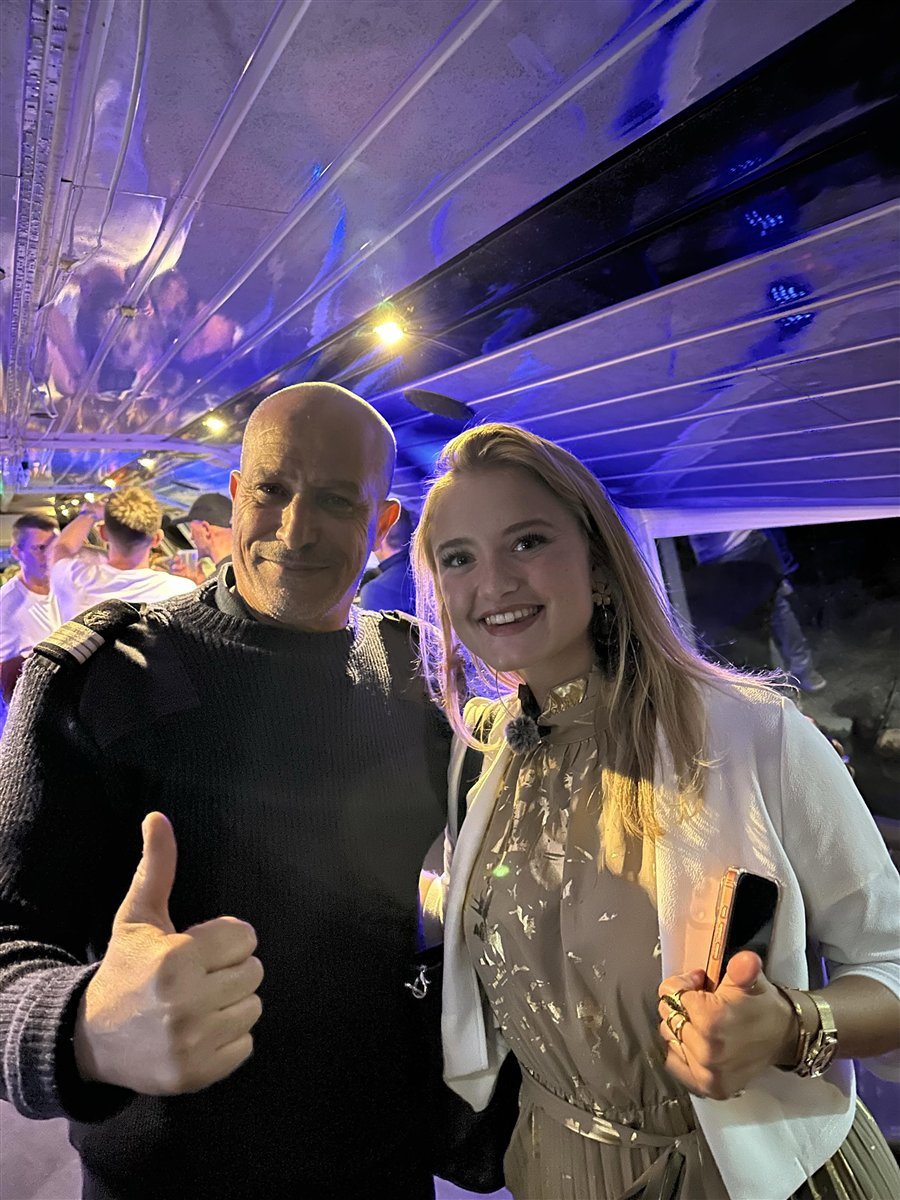 Le capitaine Aziz en tenue, à bord du Battant lors d'une soirée événementielle éclairée en bleu