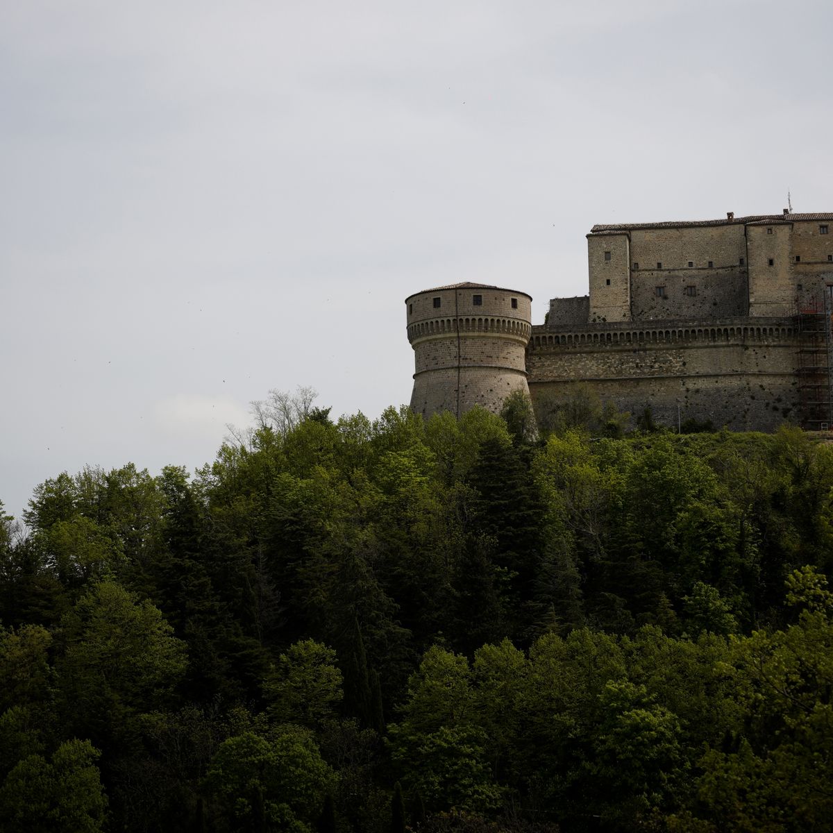 Château fortifié historique dominant une colline verdoyante, support d'étude en histoire et géographie
