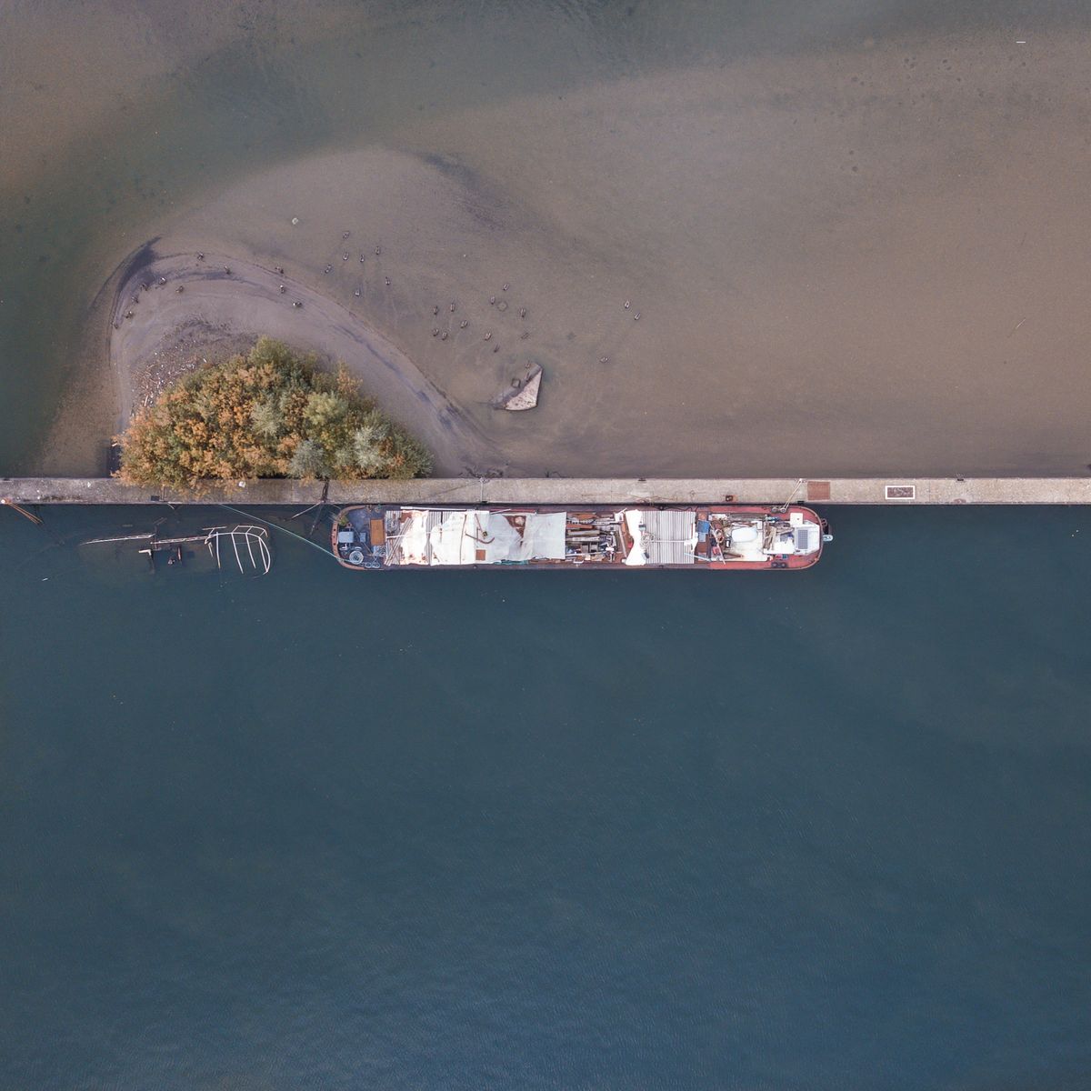 Navire à passagers vu de dessus, amarré le long d'une jetée sur l'eau